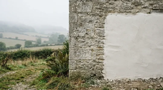 Traditional stone cottage wall with breathable lime plaster in humid conditions