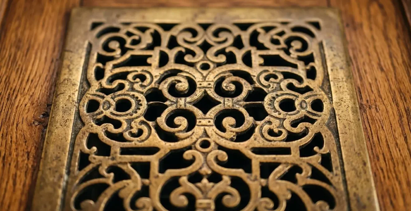 Close-up detail of decorative brass fretwork ventilation grille on vintage wood cupboard