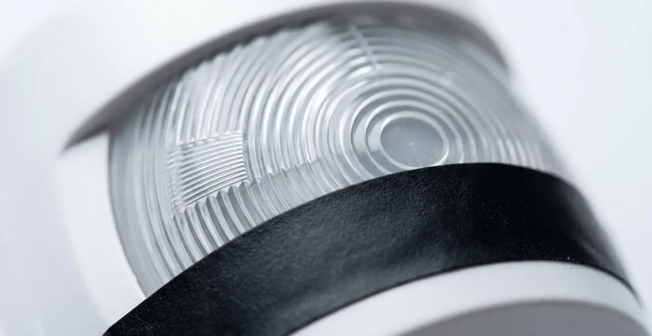 Close-up of motion sensor Fresnel lens with precision tape masking applied to lower zones, demonstrating physical pet immunity customisation method