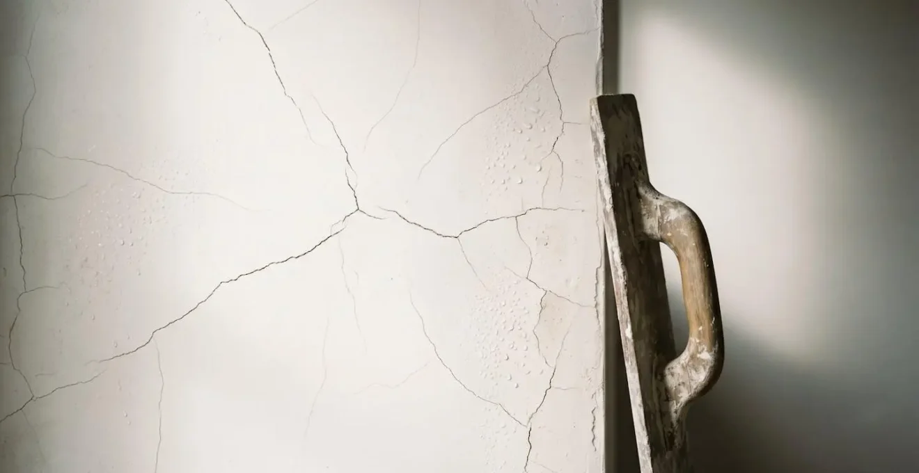 Detailed view of hairline cracks forming across lime plaster surface due to rapid moisture loss