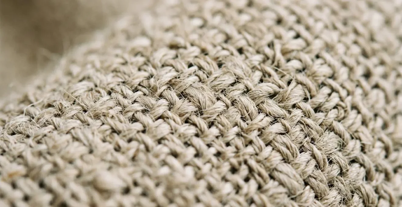 Extreme close-up macro photograph of heavyweight linen upholstery fabric showing intricate weave structure and natural fiber texture